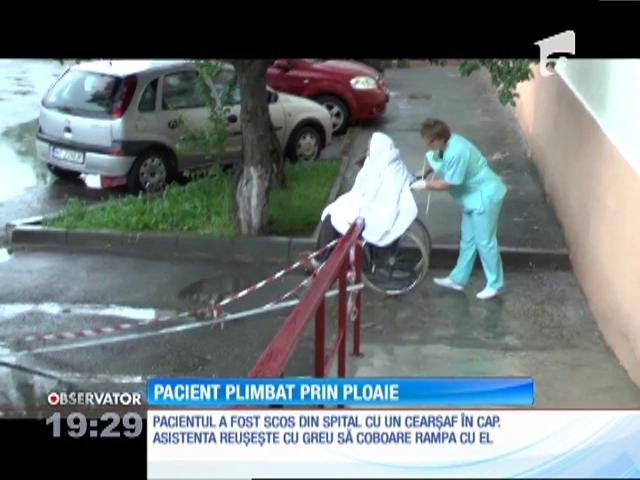 Imagini şocante la cel mai mare spital din judeţul Neamţ. Un pacient &icirc;n v&acirc;rstă este transportat cu căruciorul, prin ploaie, de o infirmieră