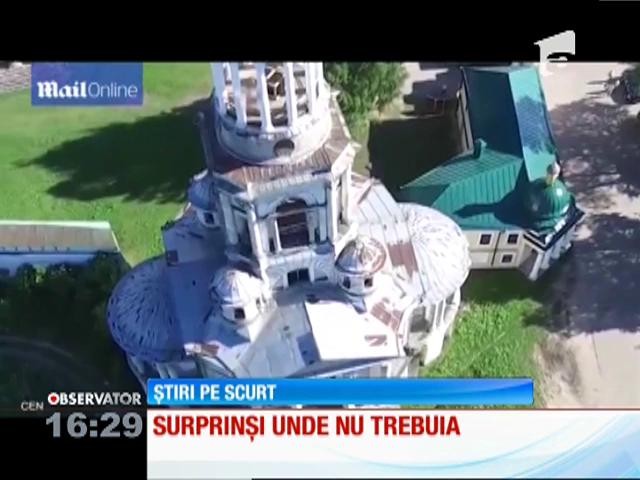 Doi turişti, suprinşi &icirc;n ipostaze intime &icirc;n turla unei biserici