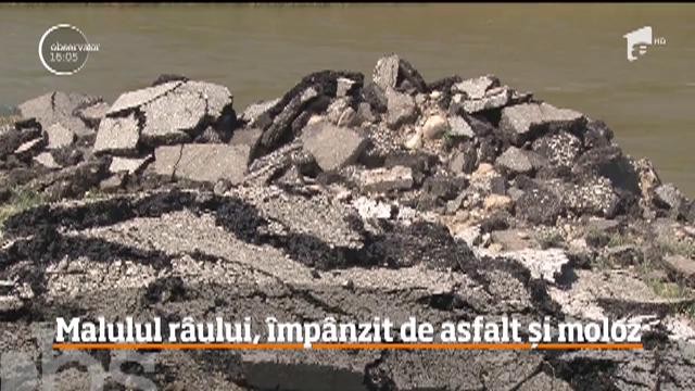 Zeci de tone de asfalt și moloz au fost depozitate pe malul unui r&acirc;u din Hunedoara