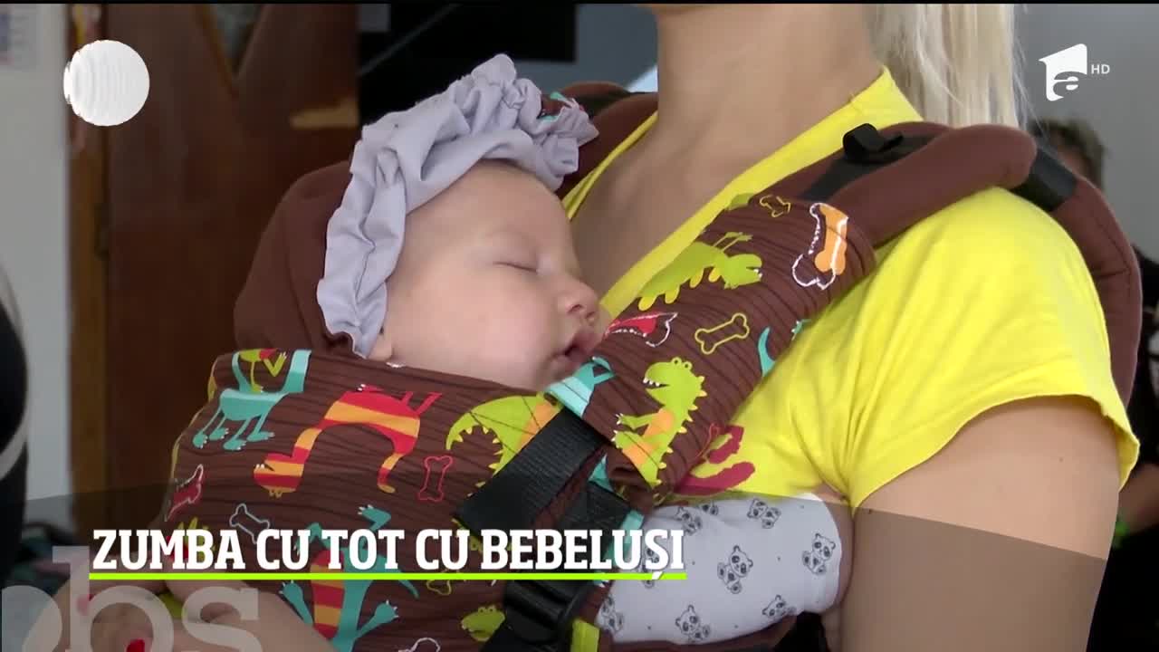 Tinerele mămici merg la sala de sport și fac zumba cu tot cu bebelușii lor, pe care &icirc;i ţin &icirc;ntr-un ham special