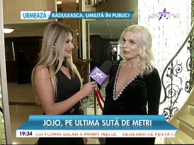 Mai are un pic şi naşte, dar Jojo poartă o rochie cu decolteu generos şi pantofi cu toc: "Cred că Achim şi-a chemat cumva surioara"