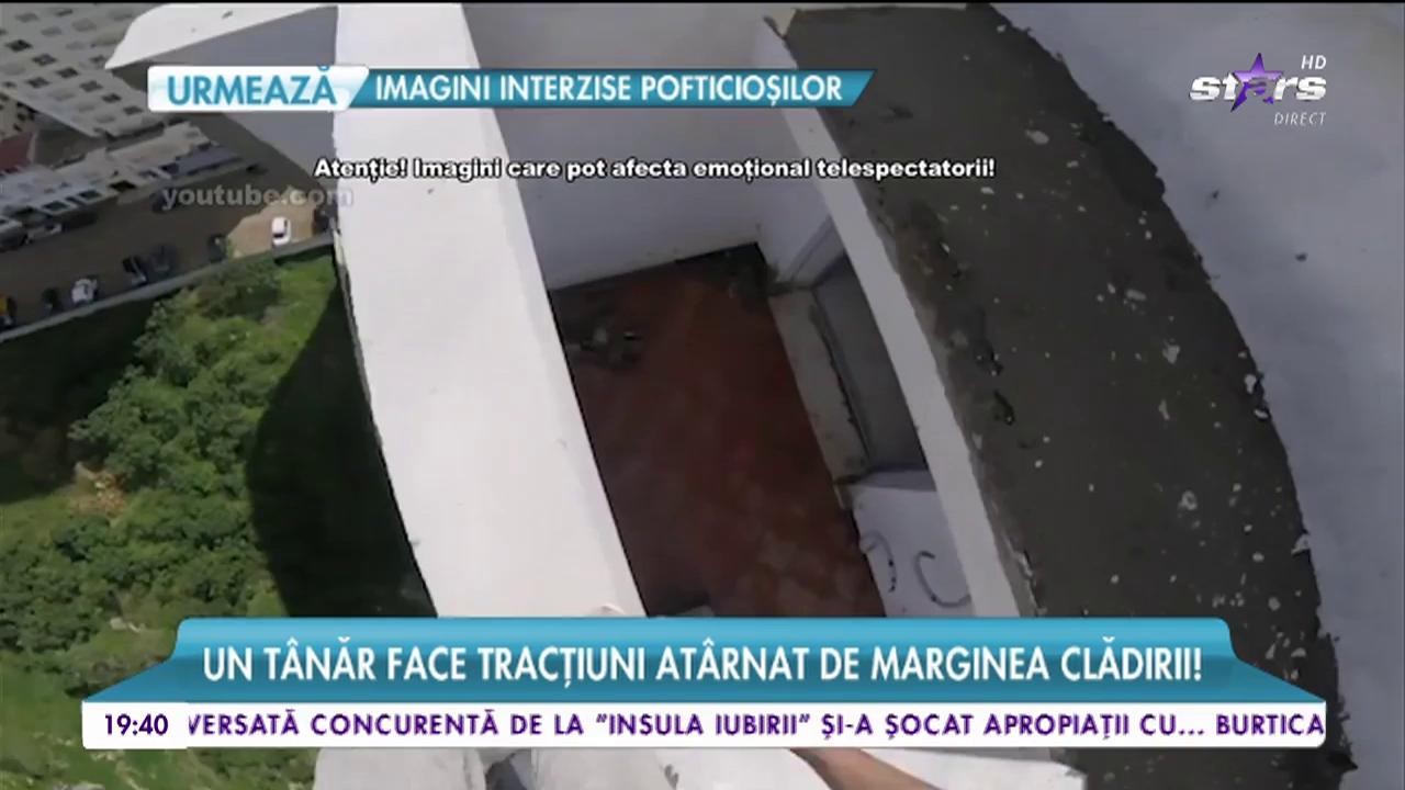 Antrenament periculos pe o clădire cu 14 etaje! Un t&acirc;năr face tracţiuni at&acirc;rnat de marginea clădirii!